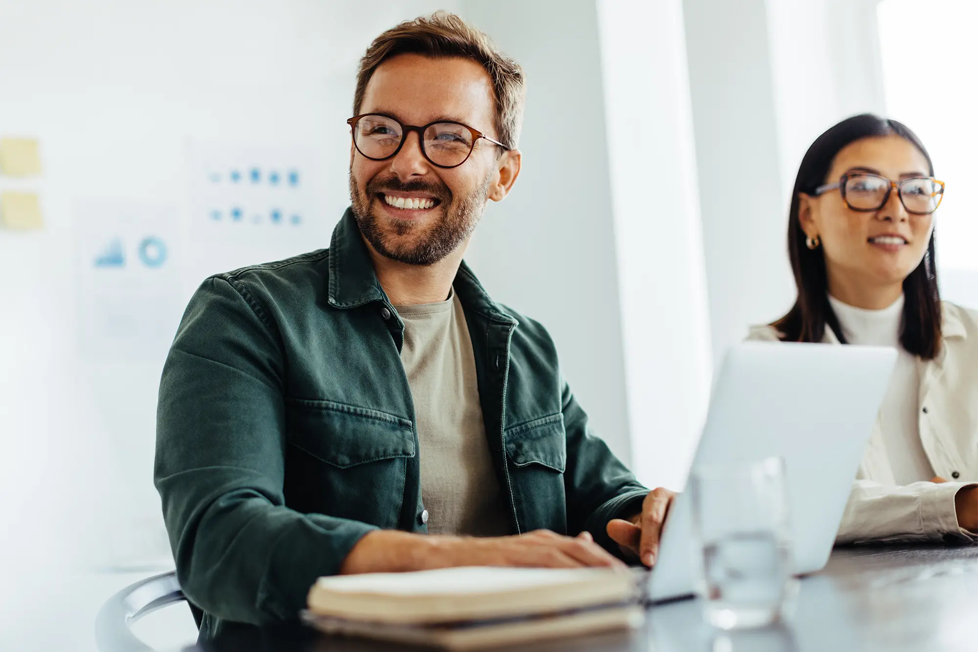 Veico Academy lachende man en vrouw met laptops - Veico - Eén gezamenlijke aanpak voor schoolveiligheid